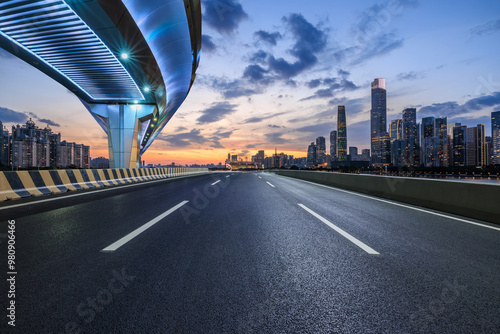 Asphalt highway road and bridge with modern city buildings at night in Guangzhou. car advertising background.