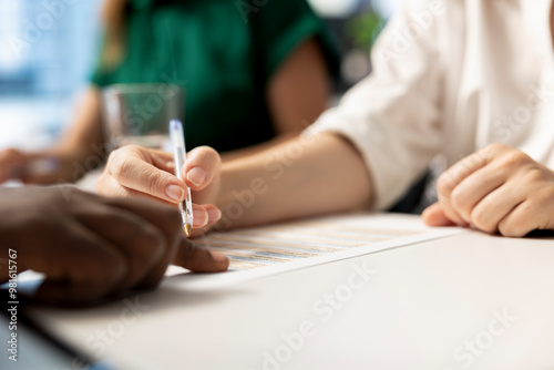 HR specialist signing contract after ensuring job candidate possesses necessary qualifications fitting for company culture. Close up of recruiter checking salary package and other benefits paperwork