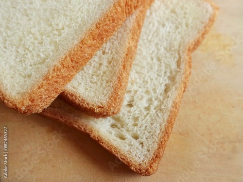 Breakfast food. Slices of white bread stacked on a wooden board . Illustration of bread.