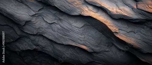  A tight shot of a rock's textured surface, illuminated from above by a yellow light emanating at its peak