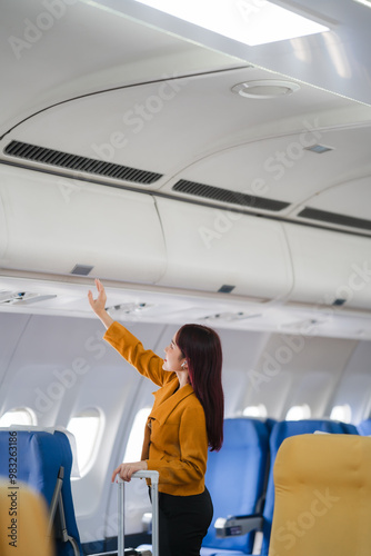 Ready for Takeoff: A young woman stows her luggage in the overhead compartment, embodying the anticipation and excitement of air travel. 