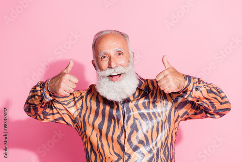 Photo of cheerful positive glad man wear stylish print clothes thumb up isolated on pink color background