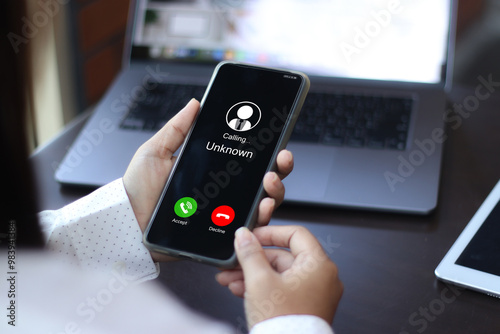 Unknown number displayed showing on smart mobile phone. Human use smartphone with incoming call from unknown number, spam, hacker, call center, crime,