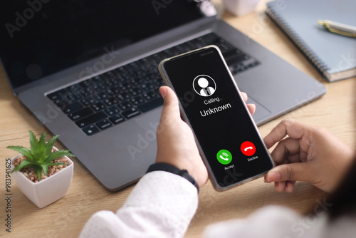 Unknown number displayed showing on smart mobile phone. Human use smartphone with incoming call from unknown number, spam, hacker, call center, crime,