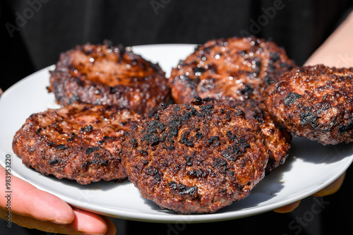 Przypalone hamburgery na talerzu, wielopierścieniowe węglowodory aromatyczne, rakotwórcze jedzenie z grilla 