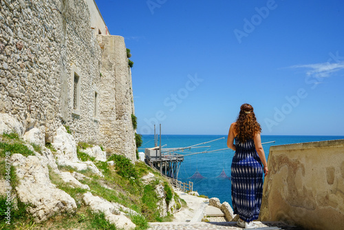 Girl visiting Vieste external walls, Gargano, Puglia, Italy