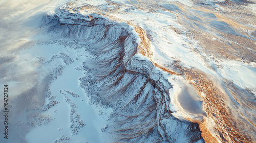 Majestic winter mountain landscape, aerial view of snowy rugged plateau, harsh terrain blanketed in white, winter wilderness concept