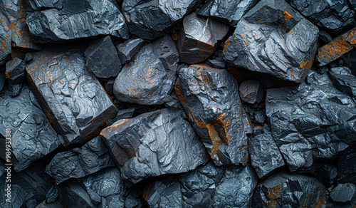 A pile of rocks with a dark grey color. The rocks are rough and jagged. Concept of ruggedness and toughness