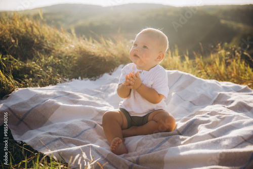 Adorable Baby Sitting on a Blanket in a Sunny Field, Embracing Nature and Wonder