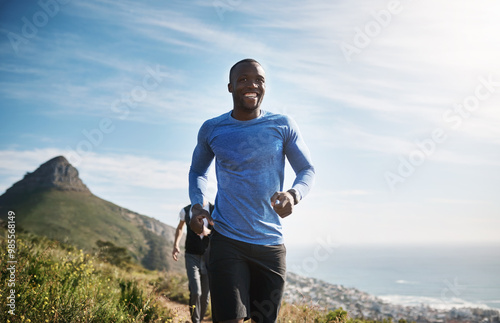 Fitness, man and group running on mountain for cardio workout, competition training and challenge. Teamwork, runner and morning jog in nature for marathon exercise, endurance and healthy body on path