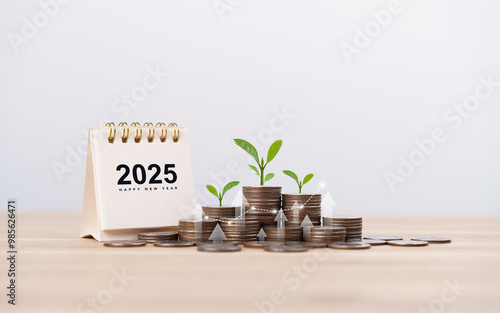 Calendar happy new year 2025 with graph and stack of growth coins. financial annual plan for save money, Budget, tax, investment, financial, savings, and New Year Resolution retirement concept.