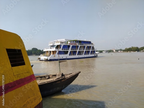 riverside scene, yellow boat foreground, large passenger ferry, muddy river, overcast sky, tropical climate, Southeast Asian waterway, contrast between small and large vessels, tourism and local trans