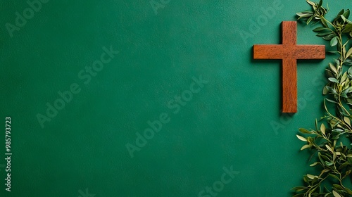 A wooden cross on a green wall with leaves