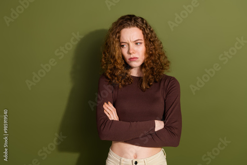 Photo of unhappy sad girl wear brown shirt looking empty space isolated khaki color background