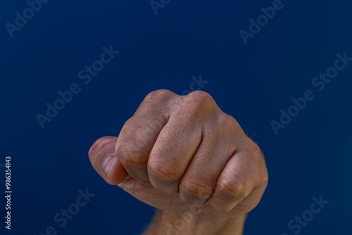 A clenched fist on a blue background - a symbol of struggle and hatred