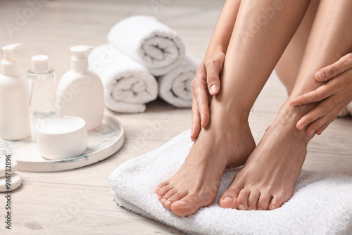 Woman touching her smooth feet on floor, closeup. Body care