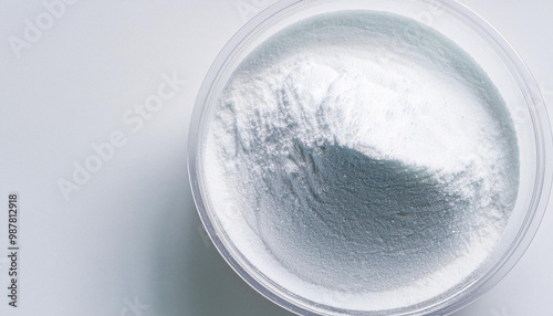 White zinc oxide powder in bowl on white table. Healthcare and medical supplement product.