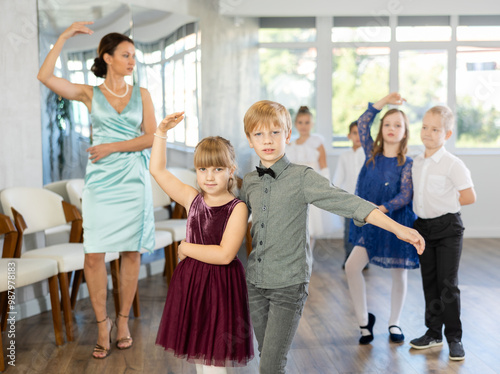 Children dance in pairs at a festive matinee