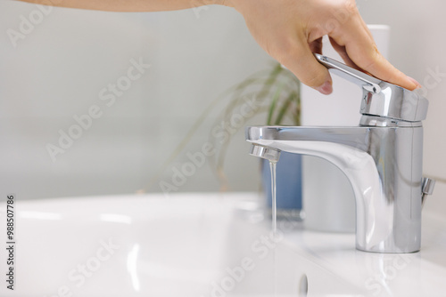 The woman tries to turn on the water in the bathtub, but little water comes out. Problems with water supply