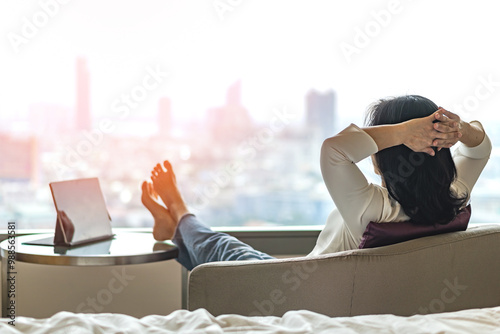 Simple lifestyle take it easy relaxation of Asian businesswoman, healthy woman resting in comfort business hotel or city home living room having lazy free time with peace of mind and work-life balance