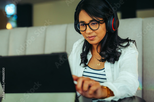 Engaged student learning with headphones on tablet in a cozy environment