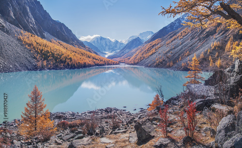 Mountain lake in the fall morning, scenic reflection, snow-capped peaks and mountain slopes