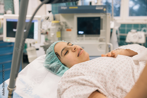 Young patient waking up after an operation in the post anaesthesia recovery unit