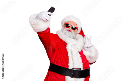 Portrait of his he nice attractive cheerful cheery positive flirty bearded Santa pouted lips taking making selfie having fun showing v-sign isolated over bright vivid shine red background