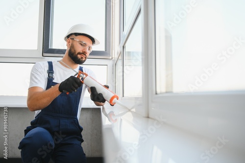 Hands applying silicone sealant that defending from water leaks and mildew. Home repair and maintenance services