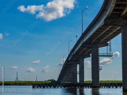 Under a bridge with a bright blue sky