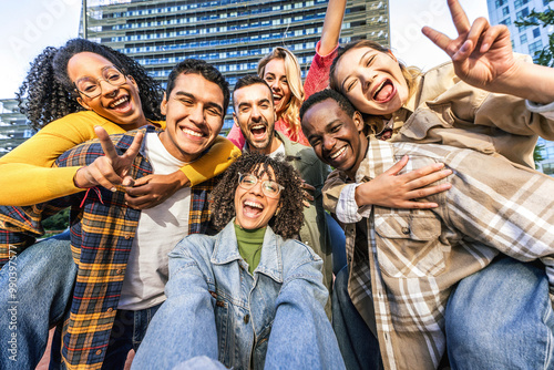 Multiracial best friends taking selfie pic with smart mobile phone in city street - Happy young people having fun hanging outside - Youth community and technology life style concept