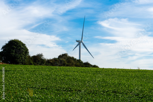 Wind turbine in rural Suffolk, UK, agricultural land in foreground. Copy space.