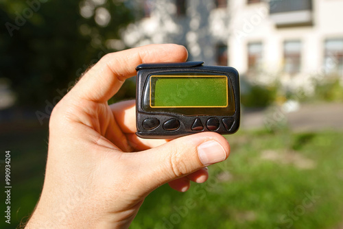 Hand holding in hand black pager, closeup. Selective focus