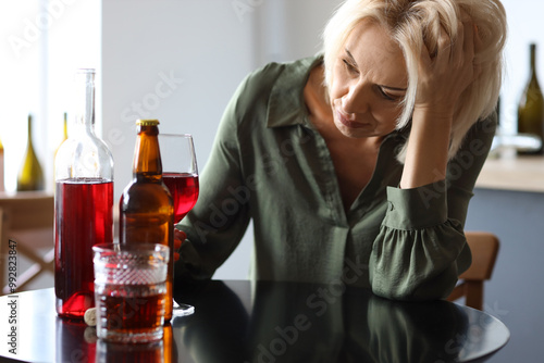 Mature woman drinking alcohol at home. Concept of alcoholism