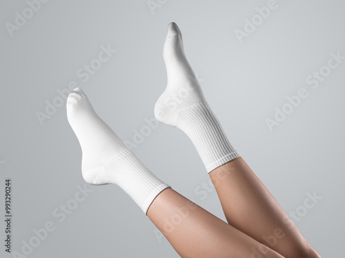 Mockup of white long socks on women's foot, with stretched toes, diagonal legs up presentation, side view, isolated on background.