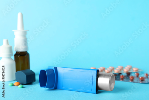 Different asthma medications on light blue background, closeup