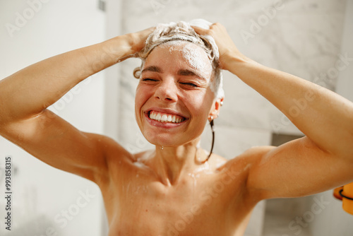 A cheerful woman lovingly enjoys washing her hair in a beautifully stylish bathroom setting filled with light and color