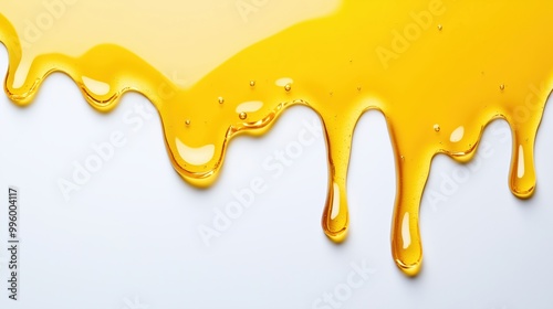 A yellow liquid is dripping down a white background