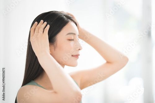 A woman massaging her head with both hands.