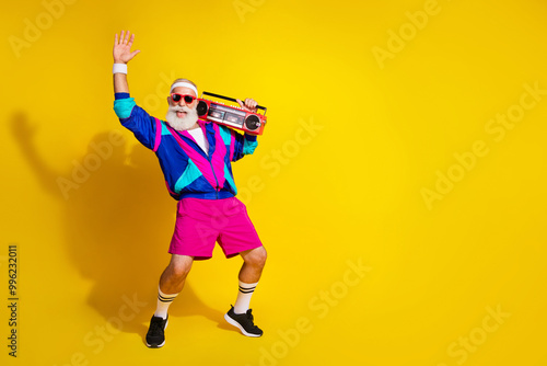 Full size photo poster of handsome granddad sportsman dance boom box wear trendy vintage sportswear isolated on yellow color background