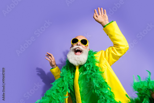 Portrait of funny extravagant aged man clubbing dancing yellow suit isolated on purple color background