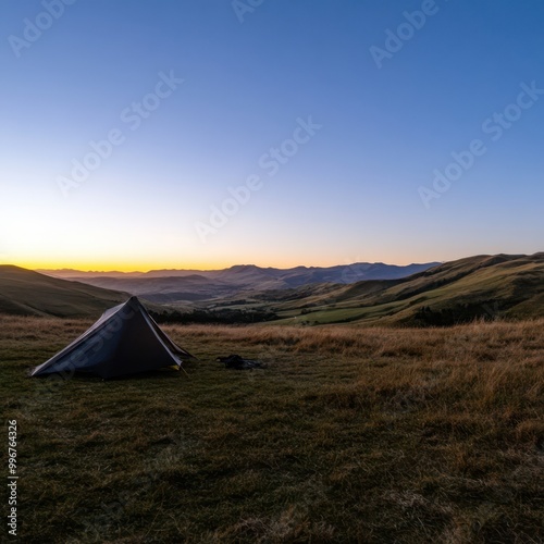 a tent is set up on a hill at sunset