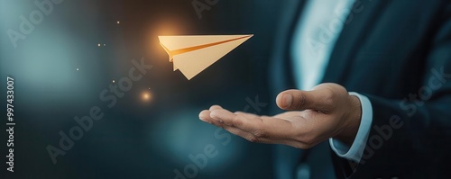 Elegant hand gesture throwing a golden paper airplane, symbolizing luxury and success in business