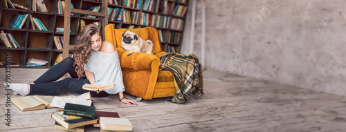 Beautiful woman reader holding the book and dog pug friend weekend in home library with orange chair and lots of bookshelves. Long horizontal banner. cozy weekend in home library relaxed hobby time