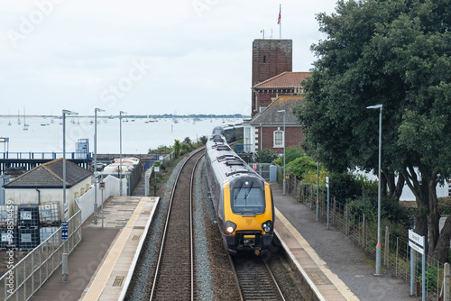 As one passenger train enters another leaves Starcross railway station on the Exe estuary in Devon UK