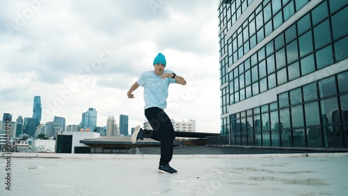 Stylish caucasian dancing man performing break dance at skyscraper. Portrait image of young happy man practicing street dance performance choreographer in modern urban city. Paris style. Hiphop.