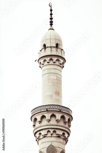 A beautifully detailed white mosque minaret stands tall against a clear sky, with intricate architectural designs and a crescent moon at the top.