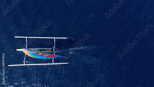 Indonesian fishing trimaran, traditional boat during fishing. Sailing trimaran in motion, drone view