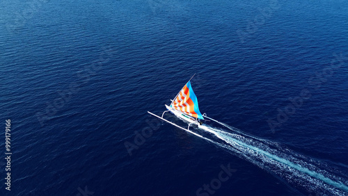 Indonesian fishing trimaran, traditional boat during fishing. Sailing trimaran in motion, drone view