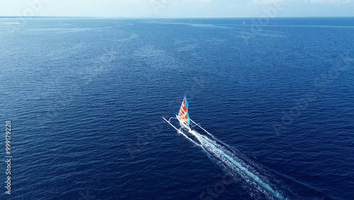 Indonesian fishing trimaran, traditional boat during fishing. Sailing trimaran in motion, drone view